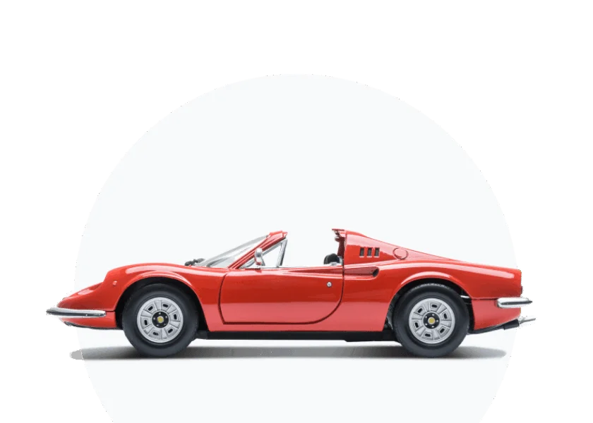 Roter klassischer Ferrari Dino Spider Sportwagen im Seitenprofil als Modellauto vor weißem Hintergrund, mit geöffnetem Verdeck und silbernen Felgen.