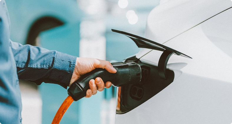 Der Ladeanschluß einen Elektrofahrzeuges wird zum beladen in das Fahrzeug gesteckt.