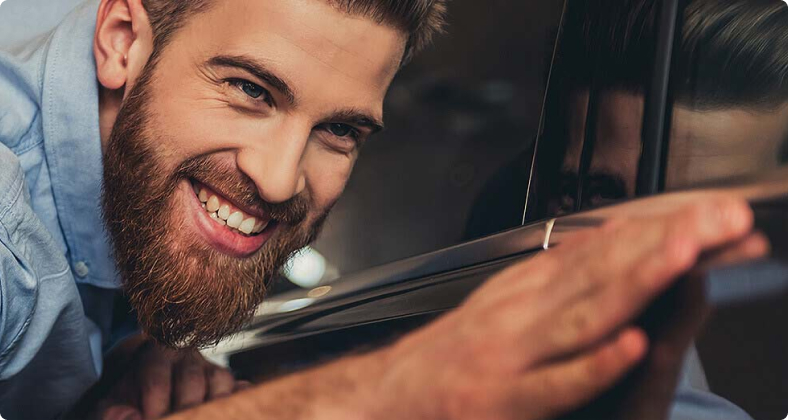 Junger Mann freut sich über sein repariertes Auto.