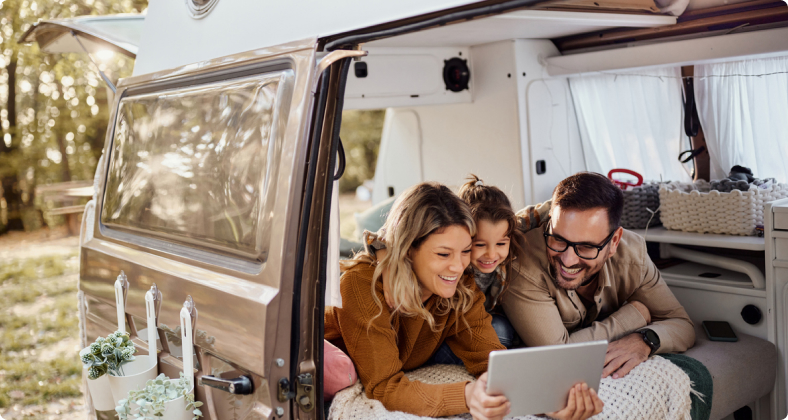 Auf einem Campingplatz liegt eine glückliche Familie liegt in ihrem Wohnmobil. 