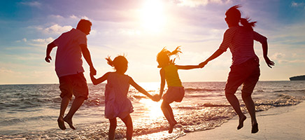 Familie spielt im Sonnenuntergang am Strand.