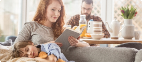 Junge Familie verbringt gemeinsame Zeit daheim im Wohnzimmer.